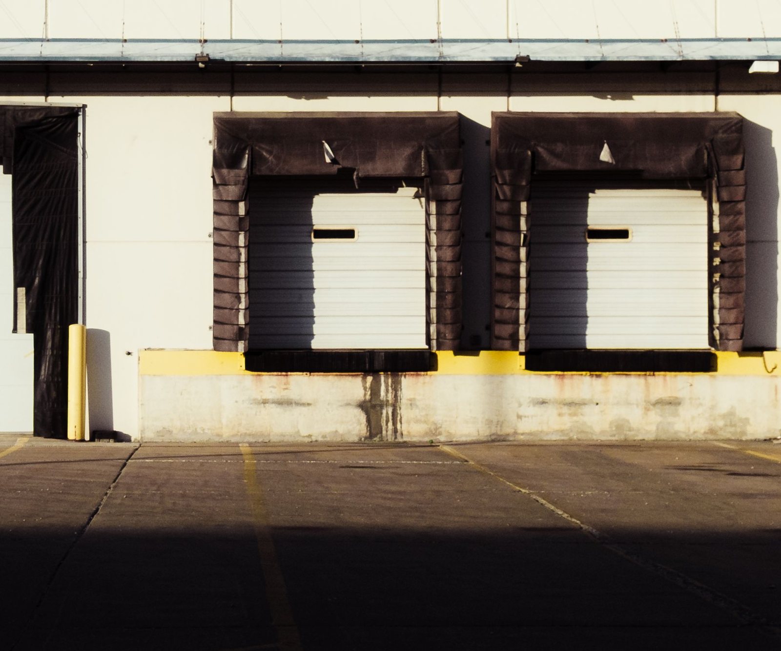 Warehouse loading dock bays above a paved apron marked for truck traffic